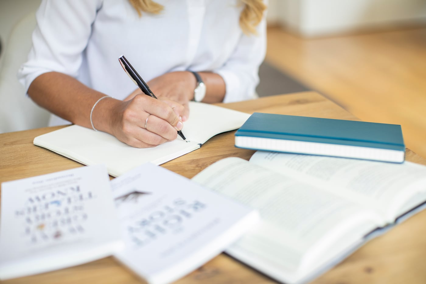 Sabrina Jordak beim Schreiben, mit Büchern und Notizbuch